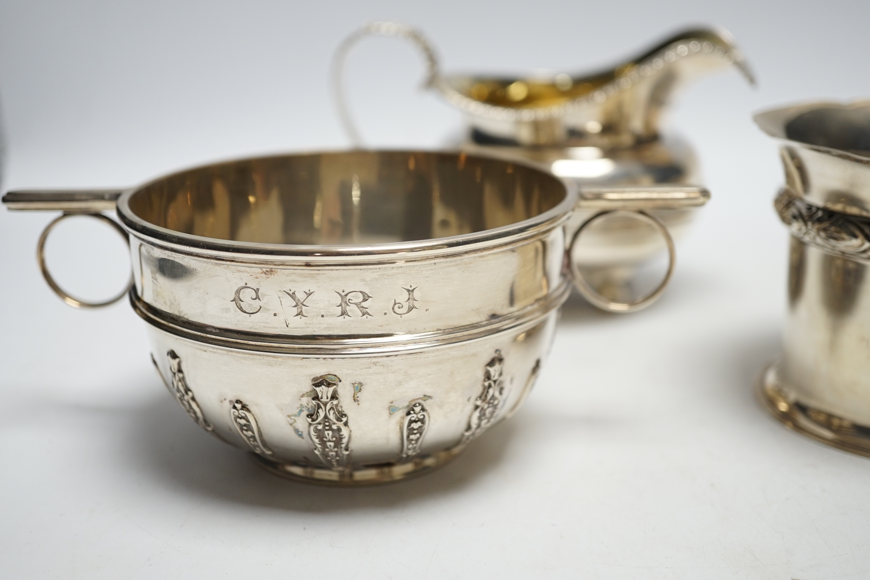 Two silver sugar bowls, London, 1877 and London, 1904, the latter with ring handles, diameter 10.8cm, a silver small vase and a George IV silver cream jug, 21.9oz.